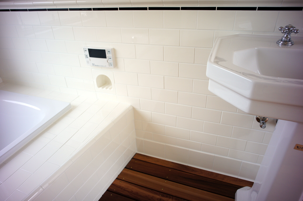 white subway tile on bathroom wall and outside of tub